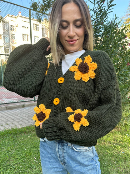 military green cardigan, sunflower knit cardigan, cozy green sweater, hand-knitted sunflowers, relaxed fit cardigan, soft yarn sweater, casual knitwear, earthy tone cardigan, unique floral design, stylish layering piece