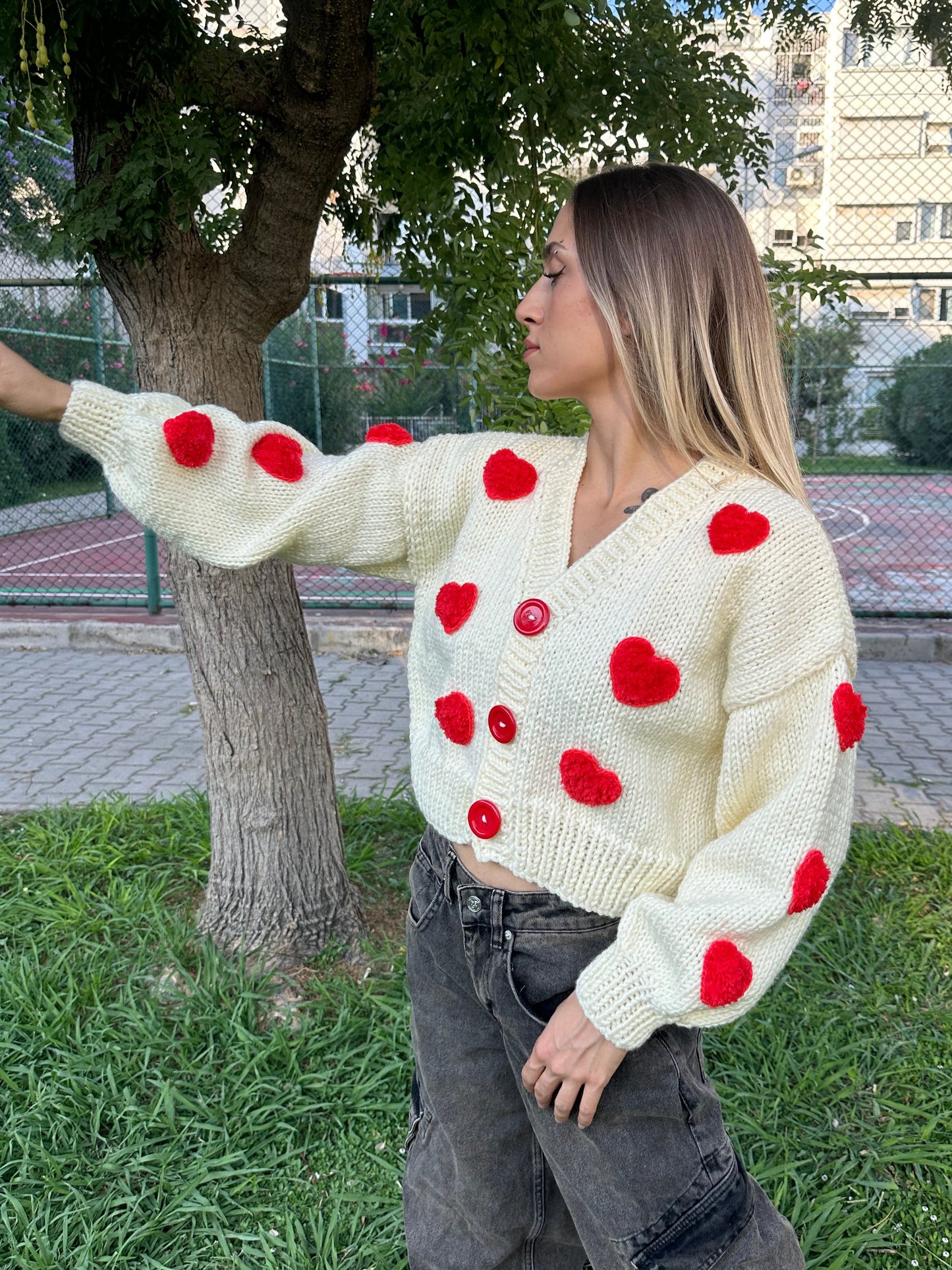 white heart cardigan, Valentina cardigan, cozy knit sweater, red heart design, soft fabric cardigan, relaxed fit sweater, playful heart details, casual knitwear, stylish layering piece, cheerful winter cardigan