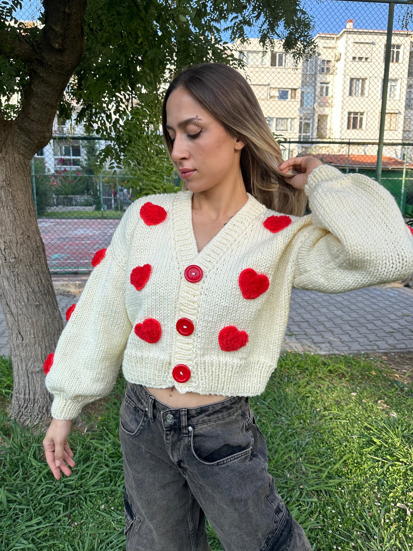 white heart cardigan, Valentina cardigan, cozy knit sweater, red heart design, soft fabric cardigan, relaxed fit sweater, playful heart details, casual knitwear, stylish layering piece, cheerful winter cardigan