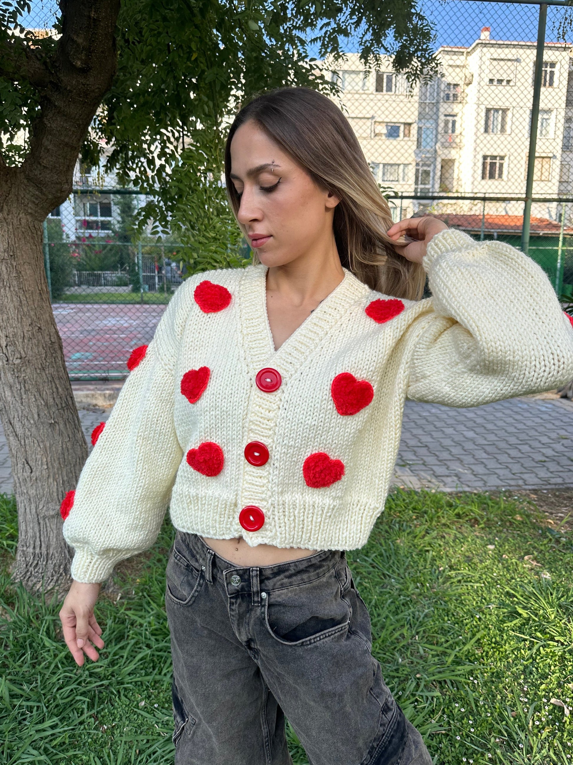 white heart cardigan, Valentina cardigan, cozy knit sweater, red heart design, soft fabric cardigan, relaxed fit sweater, playful heart details, casual knitwear, stylish layering piece, cheerful winter cardigan