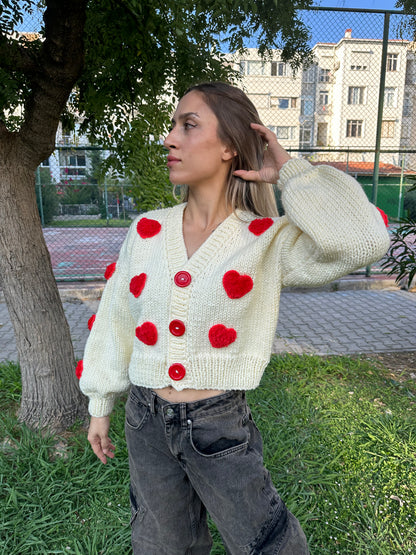 white heart cardigan, Valentina cardigan, cozy knit sweater, red heart design, soft fabric cardigan, relaxed fit sweater, playful heart details, casual knitwear, stylish layering piece, cheerful winter cardigan