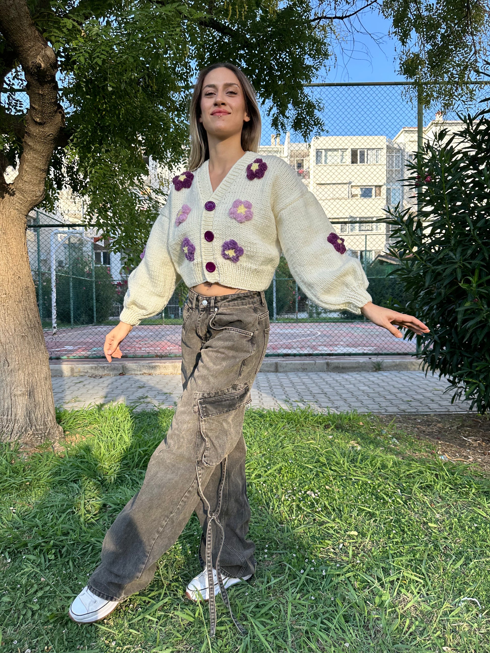 

bone-colored cardigan, violet flower cardigan, cozy knitwear, floral knit cardigan, soft yarn cardigan, elegant layering piece, feminine cardigan, stylish fall sweater, delicate floral details, comfortable fashion